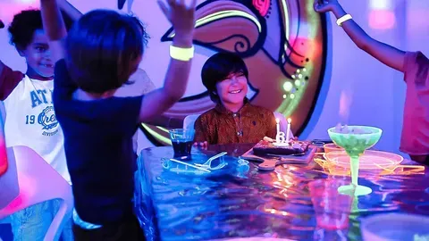 Enfants réunis pour un anniversaire sous des lumières néon