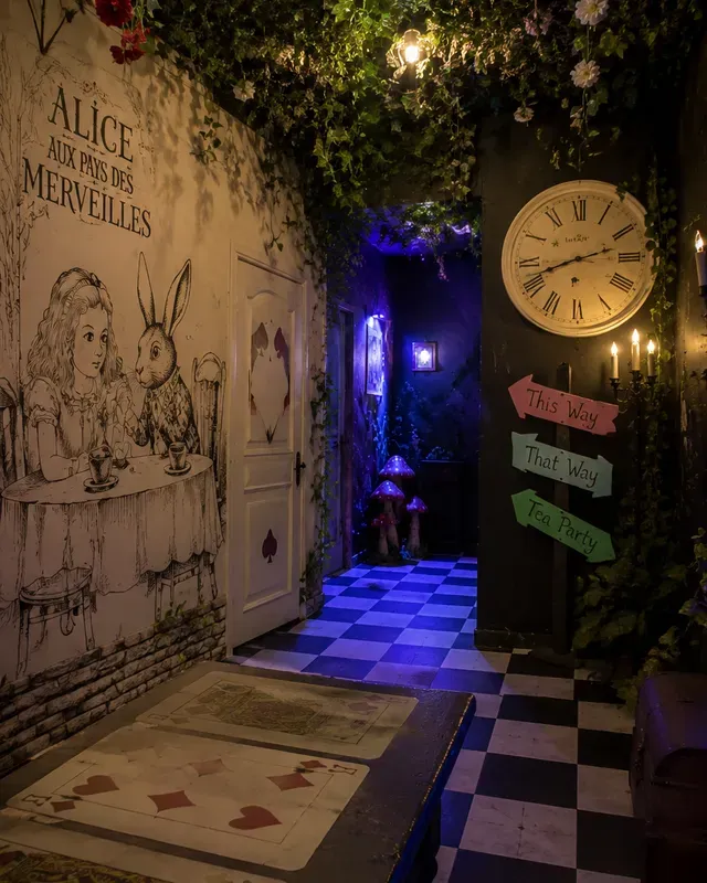 Couloir de l'escape game décoré sur le thème d'Alice au pays des merveilles, sol en damier, horloge et panneaux fléchés